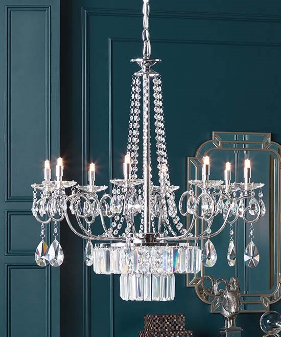 A crystal chandelier hangs in a teal room.