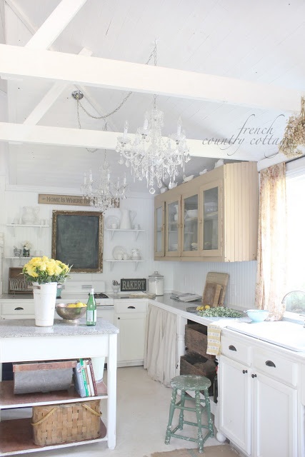 Two crystal chandeliers hang over a kitchen area.