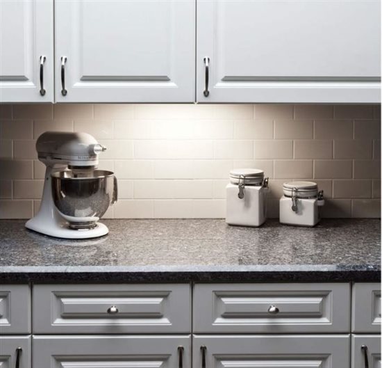 A kitchen countertop glows with under cabinet lighting.