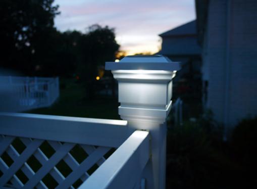 An outdoor light on an outdoor railing.