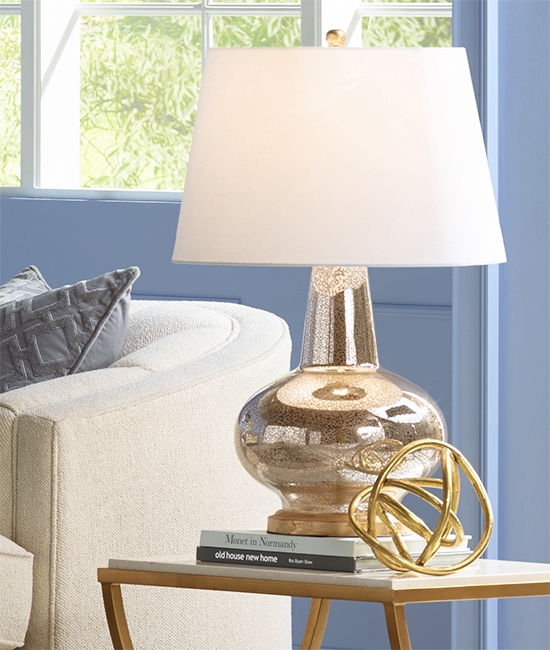 A table lamp with a mercury glass finish base.