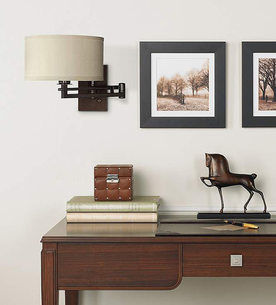 A bronze swing arm lamp over a table.