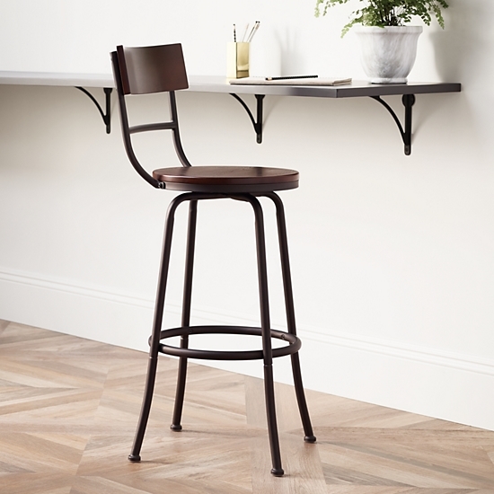An armless barstool next to a raised work space.