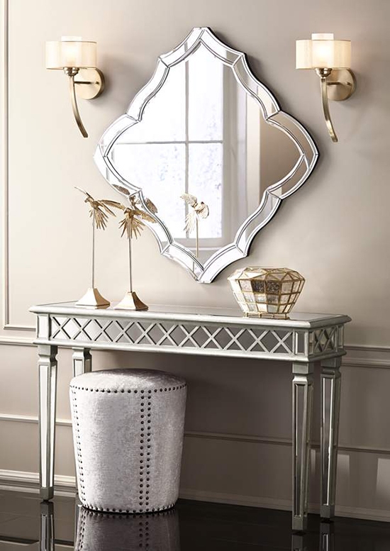 Wall sconces are installed on opposite sides of a mirror.