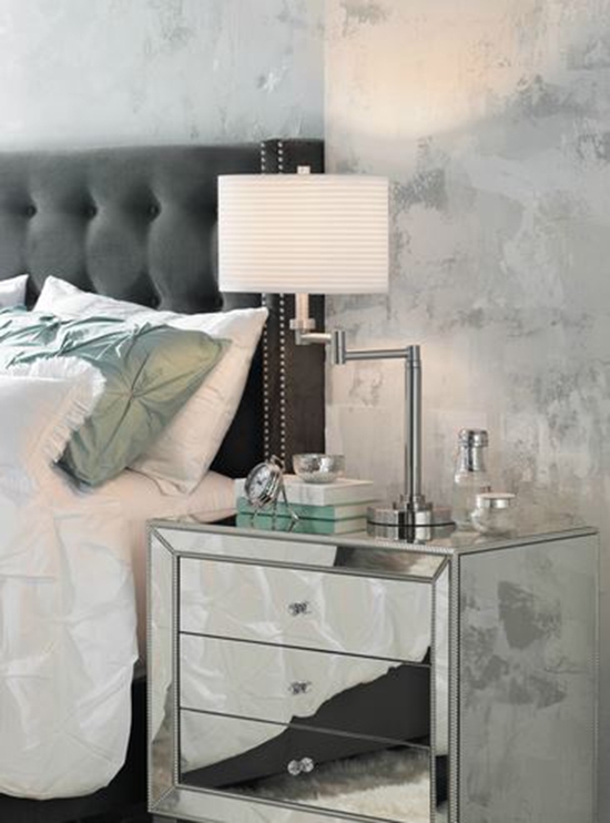 Chrome swing arm table lamp on a mirrored nightstand. A chrome swing arm table lamp.