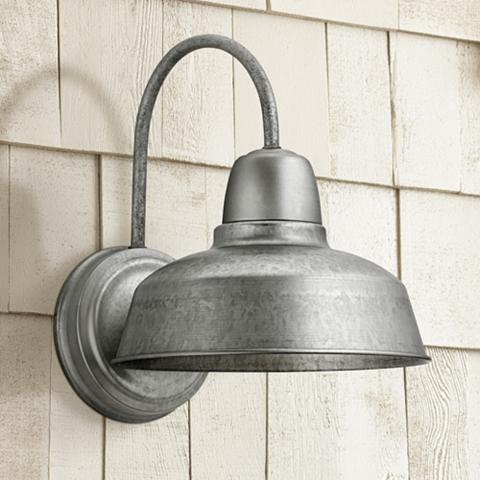 A galvanized steel finish barn light in a rustic setting.