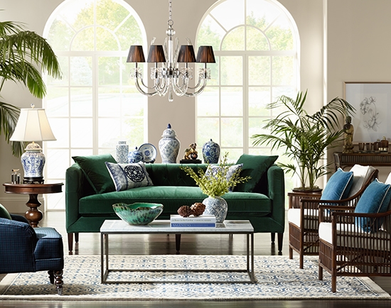 Transitional living room with emerald green velvet sofa and crystal chandelier with shades