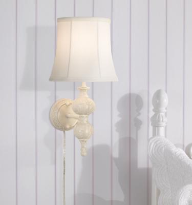 A plug-in wall sconce in a bedroom setting. 