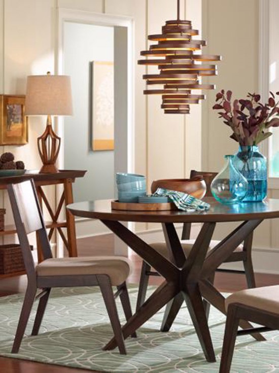 A modern chandelier hangs over a dining room table.