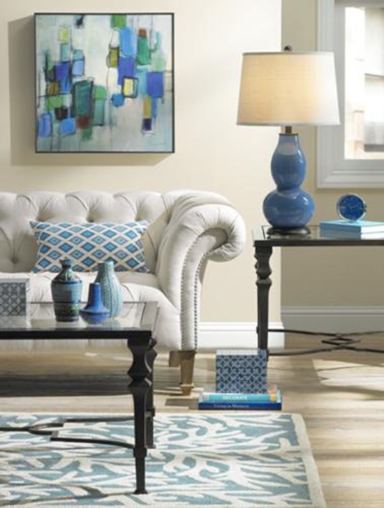 A living room setting with a blue gourd table lamp. 