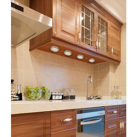 A set of four round puck lights in a transitional kitchen.