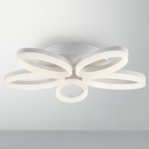 A contemporary white close to ceiling light in a flower shape. 