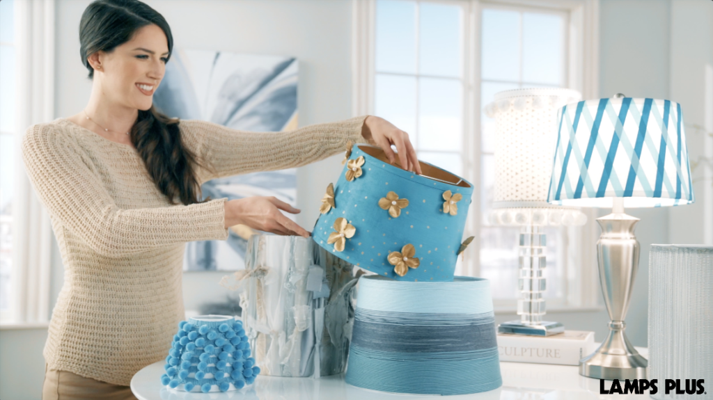 A selection of homemade lamp shades. A woman viewing her homemade lamp shades.