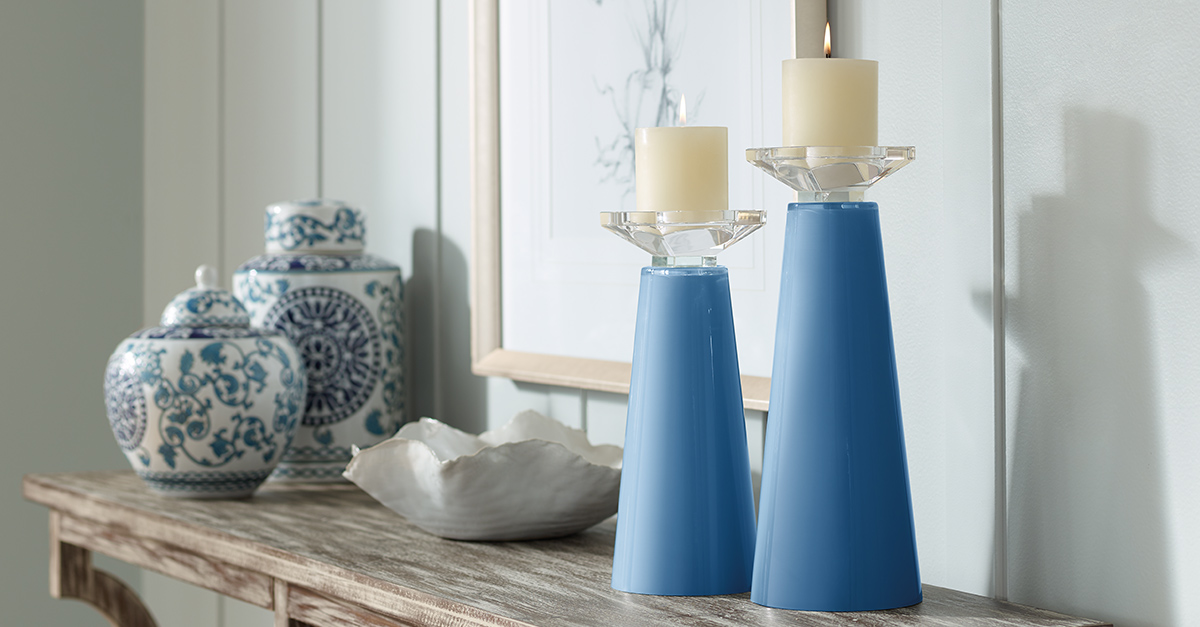 Two color plus candle holders in blue on a console table. 