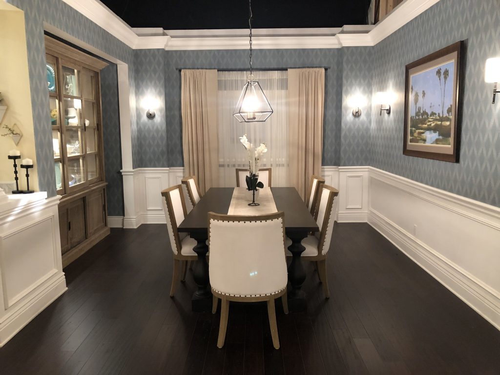 A simple but classy dining room , with a light hanging over a dining table.