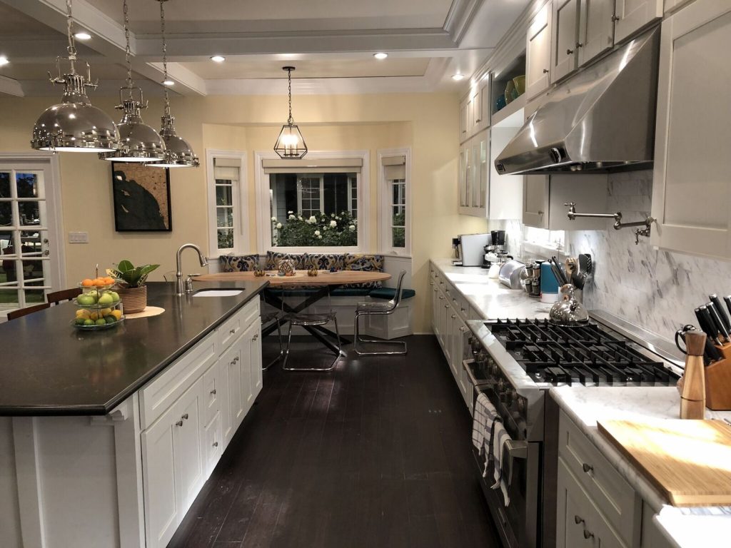 An open modern kitchen, with noticeable pendant lighting.